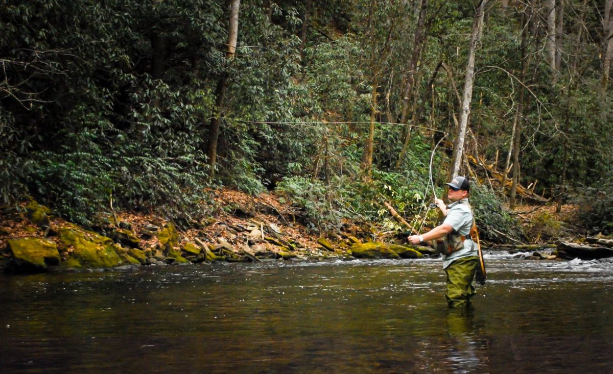 A man flyfishing in a river. 